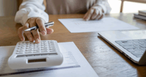 cta - CPA who thinks like a CFO analyzing business growth charts with calculator and laptop on desk