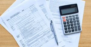 Professional tax preparation with calculator, pen, and IRS forms on desk – expert CPA services by Meinershagen & Co. in Missouri and Kansas.